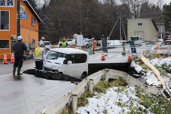 A vehicle is seen on a collapsed road in Tohoku town in Aomori Prefecture on December 9, 2025, following a 7.5 magnitude earthquake off northern Japan.  (AFP) 