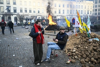 A farmer sits in a chair next to potatoes near the European Parliament at the Place du Luxembourg, during a farmers' protest to denounce the reforms of the Common Agricultural Policy (CAP) and trade agreements such as the Mercosur, in Brussels, on December 18, 2025, organised by Copa-Cogeca, the main association representing farmers and agricultural cooperatives in the EU. EU Farmers, particularly in France, worry the Mercosur deal -- which will be discussed at the EU leaders meeting -- will see them undercut by a flow of cheaper goods from agricultural giant Brazil and its neighbours. They also oppose plans put forward by the European Commission to overhaul the 27-nation bloc's huge farming subsidies, fearing less money will flow their way. (Photo by NICOLAS TUCAT / AFP)