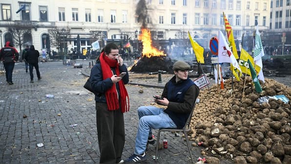 Farmers light fires outside the European Parliament building in Brussels