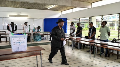 Ivory Coast's President Alassane Ouattara walks to the voting booth to cast his ballot at a polling station at the Lycee Saint-Marie in Cocody, the residential district of Abidjan on December 27, 2025 during Ivory Coast's legislative elections. AFP