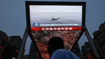 A person looks at a screen showing news footage of military drills conducted in areas around the island of Taiwan by the Eastern Theatre Command of the Chinese People's Liberation Army (PLA), in Beijing, China, on May 23, 2024. Reuters File
