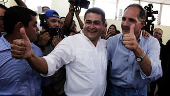 Juan Hernandez (left) and Nasry Tito Asfura of the National Party of Honduras gesture after Asufra cast his vote in Tegucigalpa on November 24, 2013. (Photo: Jorge Cabrera/Reuters) 
