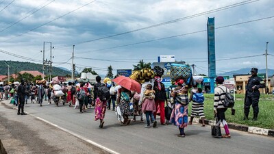 Members of the Rwandan security forces accompany a group freshly displaced people from the Democratic Republic of Congo in Bugarama on December 5, 2025, as they arrive in Rwanda after fleeing intense shelling in the bordering Kamanyola region. (Photo: AFP)