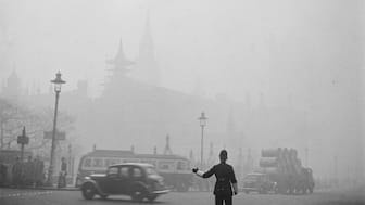 A traffic policeman works in London during the Great Smog of London, 1952. Wikimedia Commons