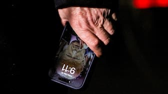 US President Donald Trump holds a mobile phone with his image on it, after his return from Pennsylvania, at Joint Base Andrews, Maryland, US, May 30, 2025. File Image/Reuters