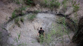 Oszkár Nagyapáti, farmer and member of the volunteer water guardians, stands in a hole in Kiskunmajsa, Hungary, Tuesday, July 29, 2025. Image Credit: AP