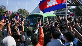 Cambodian people welcome soldiers, who had been captured by Thai soldiers in July, as a bus passes by as they leave the premises of the former international airport in Phnom Penh on December 31, 2025. Image Credit : AFP
