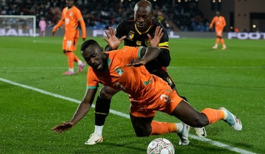 Ivory Coast's Ghislain Konan is challenged by Cameroon's Christian Bassogog during the Africa Cup of Nations group F soccer match between Ivory Coast and Cameroon, in Marrakech, Morocco, Sunday, Dec. 28, 2025. AP