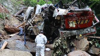 A forensic official inspects the site of a bus crash near the municipality of Remedios in Colombia’s Antioquia Department, where the vehicle veered off the road, killing 17 people and injuring 20 others, on December 14, 2025. (AFP)