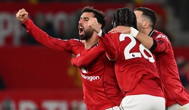 Manchester United's Portuguese midfielder #08 Bruno Fernandes (L) celebrates scoring their third goal to equalise 3-3 during the English Premier League football match between Manchester United and Bournemouth at Old Trafford in Manchester, north west England, on December 15, 2025. AFP