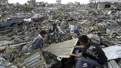 Survivors retrieve a cart from the rubble of the devastated commercial district of Banda Aceh, the capital of Aceh on December 31, 2004. File image/AP