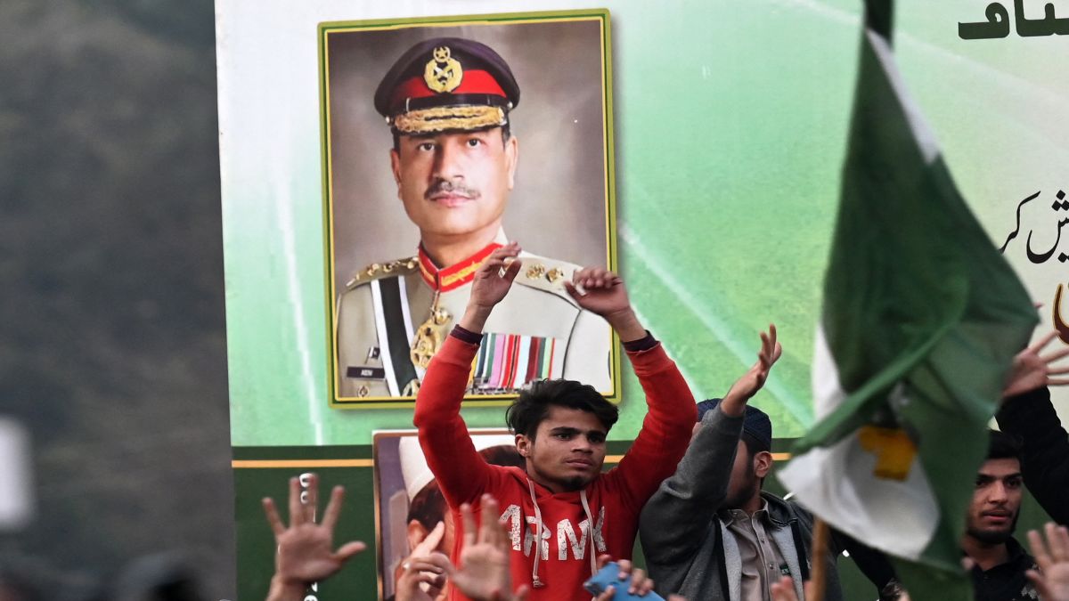 A man stands in front of a poster of Pakistan's newly-appointed Chief of Defence Forces Asim Munir. File image/AFP A man stands in front of a poster of Pakistan's newly-appointed Chief of Defence Forces Asim Munir. File image/AFP