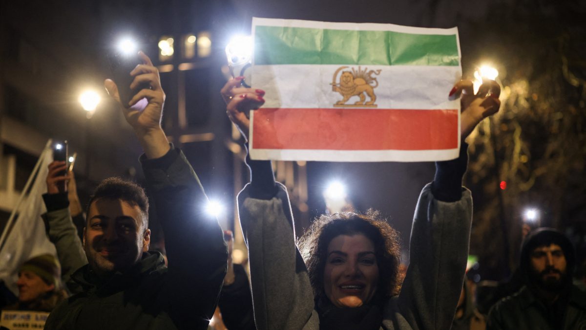 A woman holds up a paper print of the "Lion and Sun" pre-Iranian Revolution national flag as demonstrators walk toward the Iranian embassy during a rally in London, Britain. Reuters A woman holds up a paper print of the "Lion and Sun" pre-Iranian Revolution national flag as demonstrators walk toward the Iranian embassy during a rally in London, Britain. Reuters
