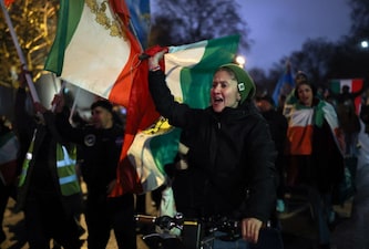 A woman displays the "Lion and Sun" pre-Iranian Revolution national flag as demonstrators walk toward the Iranian embassy during a rally in support of nationwide protests in Iran, in London, Britain, January 11, 2026. REUTERS/Isabel Infantes