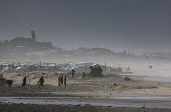 Palestinians gather near tents sheltering displaced people, amid a windstorm, in Gaza City. Reuters
