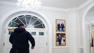 A photograph of Donald Trump with Vladimir Putin, above another of Trump and a grandchild, in the Palm Room of the White House on Tuesday. X
