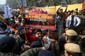Security personnel try to stop Vishva Hindu Parishad (VHP) activists along with others during a protest march near the Bangladesh High Commission in New Delhi on December 23, 2025, to condemn the killing of Hindu garment worker Dipu Chandra Das. On December 18, angry mobs in the majority Muslim nation of Bangladesh's capital of Dhaka attacked the offices of Prothom Alo and the Daily Star, torching parts of the buildings and vandalising the premises of the two publications caught up in surging anti-India sentiment in the wake of popular student leader Sharif Osman Hadi's death. The violence also saw Hindu garment worker Das killed following allegations of blasphemy. (Photo by Arun SANKAR / AFP)