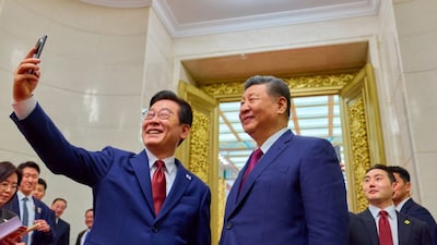 South Korea's President Lee Jae Myung (L) takes a selfie with China's President Xi Jinping (R) after a dinner at the Great Hall of the People in Beijing on January 5, 2026. AFP