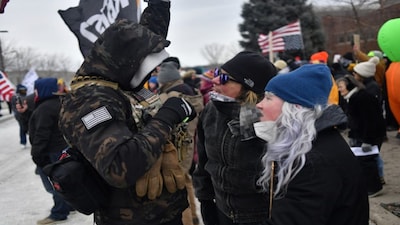 Protesters (R) are confronted by an ICE supporter during a demonstration outside the Bishop Whipple Federal Building in Minneapolis, Minnesota, on January 15, 2026. AFP