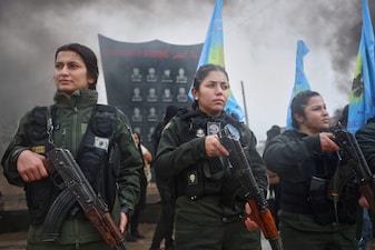 Female soldiers of the Kurdish-led, US-backed Syrian Democratic Forces (SDF) march during a military parade in Qamishli, northeastern Syria. AP