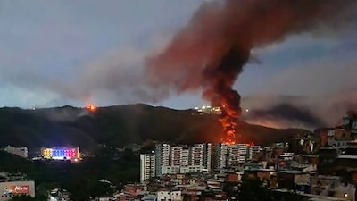Fire at Fuerte Tiuna, Venezuela's largest military complex, is seen from a distance after a series of explosions in Caracas on January 3, 2026. (Photo: STR/AFP)