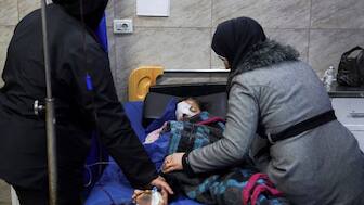 A mother sits beside her daughter who was injured during clashes between the Syrian army and the Syrian Democratic Forces (SDF) as a nurse takes care of her at a hospital in Aleppo, Syria, on January 6, 2026. (Photo: Karam al-Masri/Reuters) 