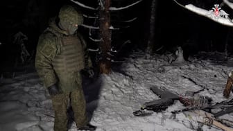 A Russian service member stands next to the remains of a drone, which, according to the Russian Defence Ministry, was downed during the repelling of an alleged Ukrainian attack on the Russian presidential residence in the Novgorod Region, in an unknown location in Russia, in this still image from a video released on December 31, 2025. Reuters File