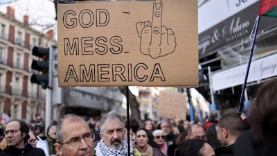 A protestor holds an anti-US slogan during a demonstration against the US operation in Venezuela to capture Venezuelan President, in front of the US Embassy in Madrid on January 4, 2026.- AFP