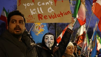 An anti-Iranian regime protester holds up a placard during a gathering outside the Iranian Embassy, central London, on January 9, 2026.- AFP