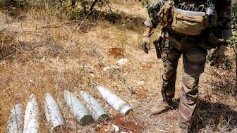A French peacekeeper of the United Nations Interim Force in Lebanon (UNIFIL) stands by munitions formerly used by Iran-backed Hezbollah at a position that was held by the group in the Khraibeh Valley in el-Meri in south Lebanon on August 27, 2025.- AFP