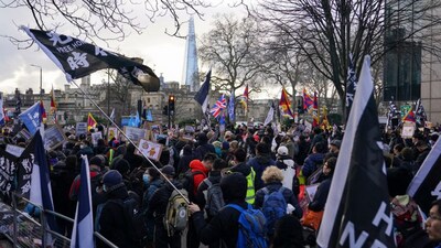 Demonstrators hold placards and flags as they attend a protest against the opening of the new Chinese embassy, in London, Saturday, Jan. 17, 2026. (AP Photo/Alberto Pezzali)

