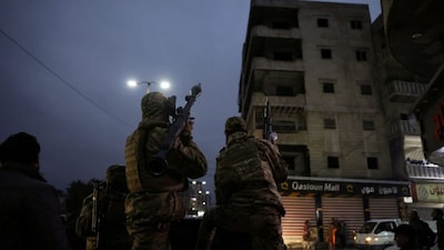 Syrian Defence Force soldiers drive through the streets the northern city of Raqa, on the North bank of the Euphrates River on January 18, 2026.- AFP