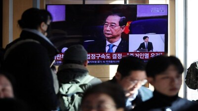 People watch a TV broadcasting a news report on South Korea's Seoul Central District Court ruling on charges against former Prime Minister Han Duck-soo for engaging in a key action of insurrection concerning ex-President Yoon Suk Yeol's declaration of martial law in December 2024, in Seoul, South Korea, on Wednesday. Reuters
