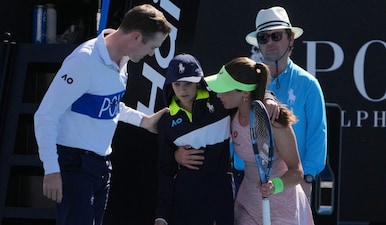Zeynep Sonmez of Turkey and umpire Chase Urban help a ball kid who fainted, from the court during her first round match against Ekaterina Alexandrova of Russia at the Australian Open tennis championship in Melbourne, Australia, Sunday, Jan. 18, 2026. AP