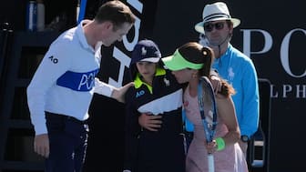Zeynep Sonmez of Turkey and umpire Chase Urban help a ball kid who fainted, from the court during her first round match against Ekaterina Alexandrova of Russia at the Australian Open tennis championship in Melbourne, Australia, Sunday, Jan. 18, 2026. AP