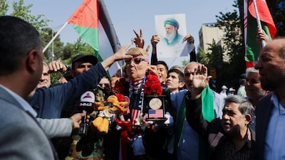 A man wearing a mask depicting US President Donald Trump attends a rally in support of the people of Gaza, after Friday prayers in Tehran, Iran, October 10, 2025. File Image/WANA via Reuters
