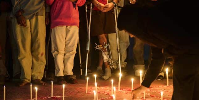 Members of Gen Z protest groups are joined by injured victims and family members of those who died during September protests at a candlelight vigil outside the Parliament building in Kathmandu, Nepal, on Dec. 9, 2025.