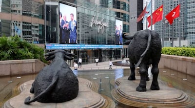 Chinese and Hong Kong flags flutter next to bull statues outside the Hong Kong Exchanges at the financial Central district in Hong Kong, China September 14, 2020. REUTERS