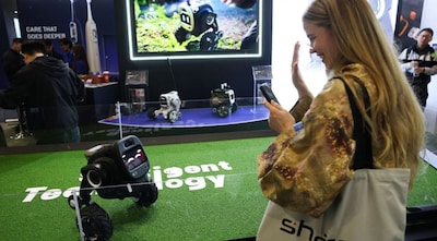 An attendee waves at the Sentigent Technology ROVAR X3 outdoor companion robot as it is demonstrated during the annual Consumer Electronics Show (CES). Image Credit: AFP