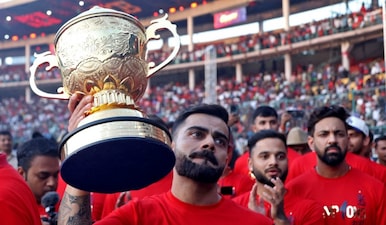 Royal Challengers Bengaluru's Virat Kohli holds up the Indian Premier League (IPL) winners' trophy at the the Chinnaswamy Stadium in Bengaluru. Reuters