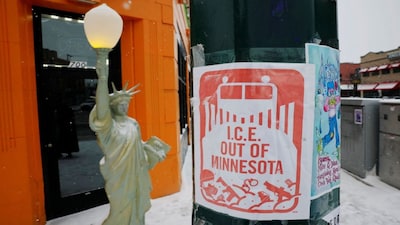 A sign reading “ICE Out of Minnesota” hangs on a lamppost in front of a decorative Statue of Liberty–themed lamp in Minneapolis, Minnesota. File image/Reuters