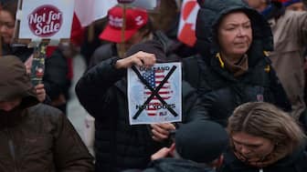 A man holds a map of Greenland covered in the American flag crossed out with an X during a protest against Trump's policy towards Greenland in front of the US consulate in Nuuk, Greenland. AP