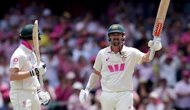 Australia’s Travis Head (R) celebrates with teammate Steve Smith after reaching his 150 runs on day three of the fifth Ashes cricket Test between Australia and England at the Sydney Cricket Ground in Sydney on January 6, 2026. AFP