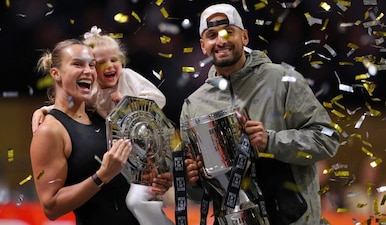Aryna Sabalenka holds her goddaughter next to Nick Kyrgios as they pose with trophies after their Battle of the Sexes tennis match, in Dubai, United Arab Emirates, Sunday Dec. 28, 2025. (Amr Alfiky/Pool Photo via AP)