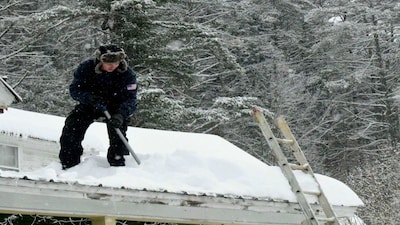 A man shovels snow off his roof before it could do damage to the building in Wardsboro, Vermont., after Winter Storm Fern dropped several inches of snow. AP
