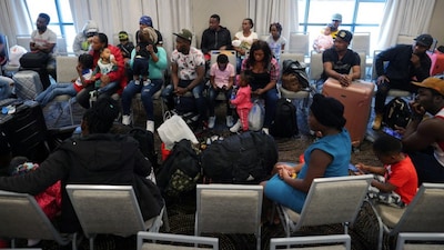  Immigrants from Haiti who recently arrived in Boston from other parts of the United States listen to instructions from representatives of La Colaborativa, a non-profit community services organization based in Chelsea, as they arrive at temporary housing in a hotel in Everett, Massachusetts, U.S. Reuters