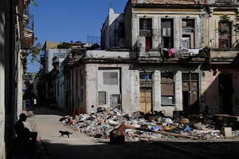 A man sits next to trash on a street in downtown Havana, Cuba, February 16, 2026. REUTERS/Norlys Perez