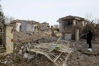 A woman looks at houses heavily damaged by a Russian missile strike, amid Russia's attack on Ukraine in Kyiv region. File image/Reuters 