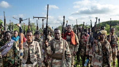 Soldiers of the Somalia National Army (SNA) raise their weapons when they gathered near their camp for a talk from visiting senior officers at Awdheegle, one of several towns recently liberated from the Al-Qaeda-linked terrorists in Somalia's lower-Shabelle region on November, 2025. AFP