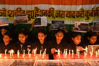 School children light candles as they pay tribute to the Indian Central Reserve Police Force (CRPF) soldiers to mark the first anniversary of a suicide attack that killed 41 CRPF soldiers in Pulwama, at a school in Amritsar on February 14, 2020. (Photo by NARINDER NANU / AFP)